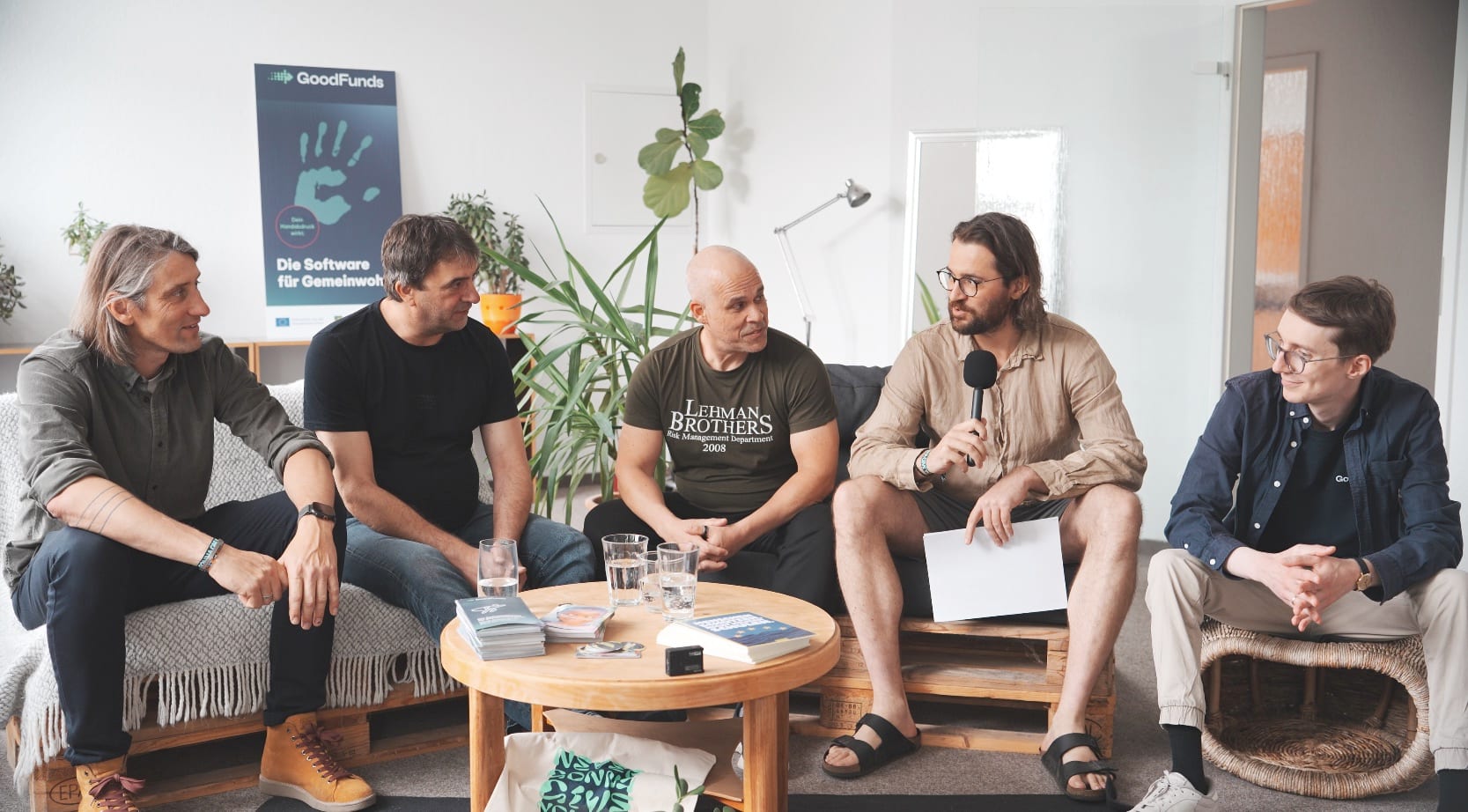 Das Team von goodDEV im Gespräch vor einem GoodFunds-Aufsteller im Dresdner Büro